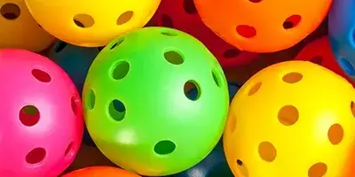 A variety of different coloured pickleballs